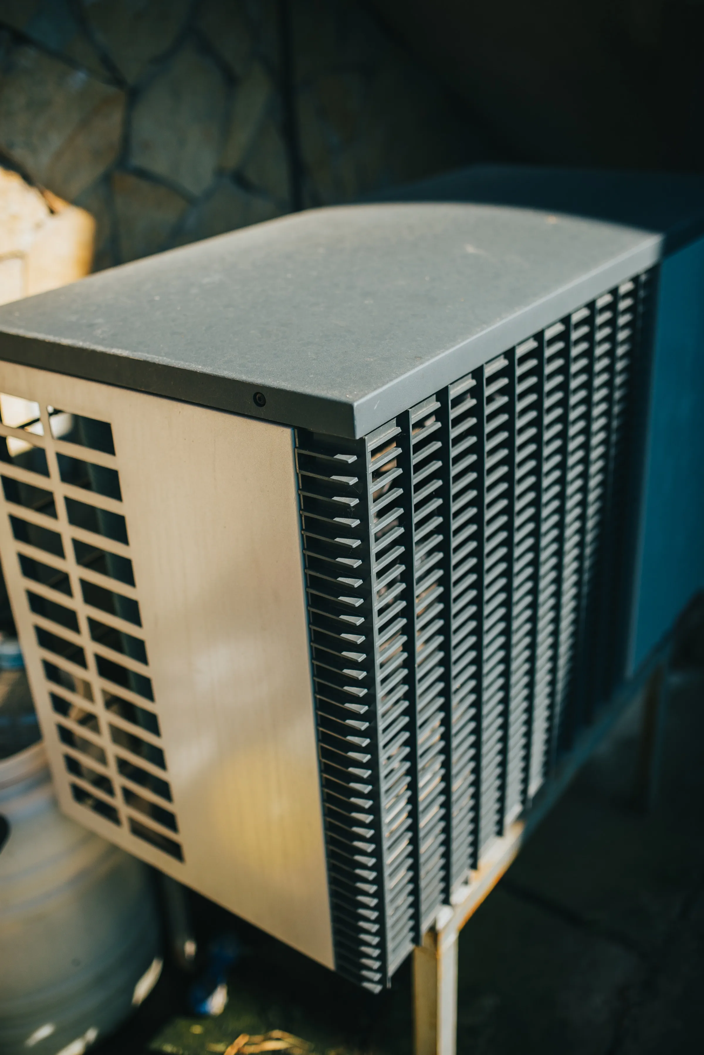 An air source heat pump unit installed outside a brick home